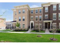Attractive brick townhomes featuring well-maintained lawns, black railings, and contemporary architectural details at 13776 Tender Dr, Carmel, IN 46032