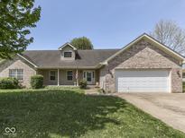Inviting single-story home with a well-manicured lawn, brick accents, and an attached two-car garage at 1858 Jenny Dr, Martinsville, IN 46151