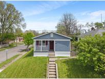 Charming blue home with a well-manicured lawn and inviting front porch, perfect for suburban living at 2263 N Rural St, Indianapolis, IN 46218