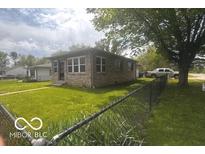 Well maintained single story home with brick facade and green lawn at 2402 S Rybolt Ave, Indianapolis, IN 46241
