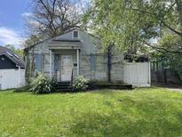 Modest house exterior features a weathered facade, small porch, and overgrown front yard at 2517 Baur Dr, Indianapolis, IN 46220