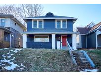 Charming two-story home featuring a bright red front door, blue siding and a welcoming front porch at 2714 N Capitol Ave, Indianapolis, IN 46208