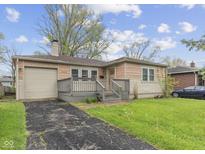 Charming home featuring a well-kept lawn, front porch, and a one-car garage enhancing its curb appeal at 3421 Arthington Blvd, Indianapolis, IN 46218