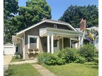 Charming single-story home with a cozy front porch and well-maintained landscaping in a residential neighborhood at 4406 Carrollton Ave, Indianapolis, IN 46205