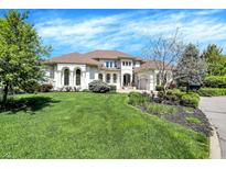A light-colored two-story home surrounded by a lush green lawn, showcasing classic architecture and landscaping at 4726 Ellery Ln, Indianapolis, IN 46250