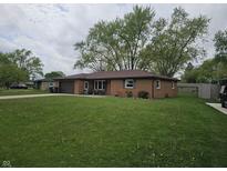 Charming single-story brick home featuring an attached garage and a well-maintained front yard at 5107 Saddle Ln, Anderson, IN 46013