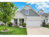 Charming home featuring a well-maintained lawn, attached two-car garage and inviting front porch at 6241 Colonial Dr, Whitestown, IN 46075