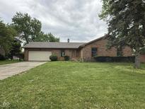 Charming brick ranch home with a lush green lawn, mature trees, and an attached two-car garage at 645 Boulder Rd, Indianapolis, IN 46217