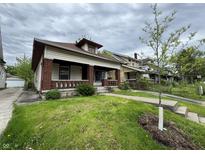 Charming home with a brick-accented porch and a freshly planted tree in the front yard at 811 N Oxford St, Indianapolis, IN 46201