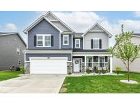 Beautiful two-story home with blue and gray siding, stone accents, and a well-manicured lawn at 8811 Dorill Creek Ln, Indianapolis, IN 46259