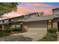 Charming townhome featuring a brick facade, attached garage, and lovely landscaping at 1030 Stratford Hall # 17-3, Indianapolis, IN 46260