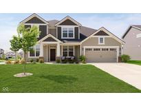 Charming two-story home showcasing a well-manicured lawn and a welcoming covered front porch at 13204 Caterwood Cir, Fishers, IN 46037