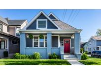 Charming home with a welcoming red door, light blue brick and siding, a well manicured lawn, and an inviting porch at 1330 Marlowe Ave, Indianapolis, IN 46202