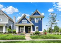 Charming two-story home with a blue exterior, inviting front porch, and well-manicured lawn at 1404 Rosebank Dr, Westfield, IN 46074