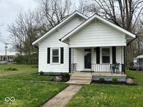 Charming home with a welcoming front porch, black shutters, and a well-manicured lawn at 1405 S Ribble Ave, Muncie, IN 47302