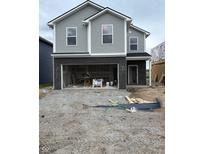 Two-story home featuring gray siding, black brick accents, and an unfinished front yard at 1439 Elm St, Martinsville, IN 46151