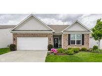 Charming brick home featuring an attached garage, manicured lawn, and a welcoming front entrance at 16044 Loire Valley Dr, Fishers, IN 46037
