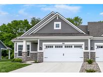 Charming home showcasing a two-car garage, stone accents, a gray facade, and a well-manicured lawn at 16693 Churning Way, Noblesville, IN 46060