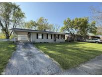Charming single-story home featuring a well-maintained lawn, covered parking, and inviting curb appeal at 1716 Arlene Dr, Indianapolis, IN 46219