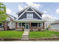 Charming two-story home with a classic front porch and lush green lawn at 1852 Singleton St, Indianapolis, IN 46203