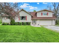 Charming two-story home featuring a well-manicured lawn, attached garage, and eye-catching red window accents at 3154 E German E Rd, Shelbyville, IN 46176
