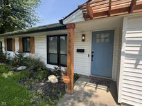 Charming home exterior featuring a blue front door, fresh white siding, and a cozy pergola at 3864 Esquire Ct, Indianapolis, IN 46226