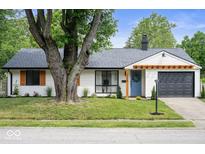 Charming single-story home featuring a tidy front lawn, blue door, and gray garage at 3864 Esquire Ct, Indianapolis, IN 46226