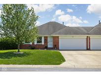 Charming brick home featuring a well-maintained lawn, mature tree, and attached two-car garage at 389 Vinewood N Dr, Brownsburg, IN 46112