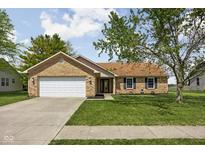 Charming single-story brick home featuring an attached two-car garage and a well-manicured lawn at 504 Countryside Dr, Lebanon, IN 46052