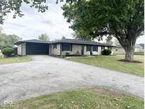 Charming single-story home features a spacious yard, attached garage, and lovely landscaping at 6811 S Meridian St, Indianapolis, IN 46217