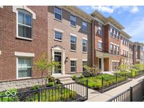 Beautiful brick townhomes with manicured landscaping and inviting entrances, offering a stylish living experience at 9422 Oakley Dr, Indianapolis, IN 46260