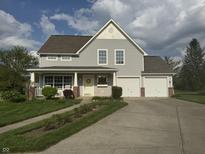 Charming two-story home with a welcoming front porch and two-car garage at 10691 Morristown Ct, Carmel, IN 46032