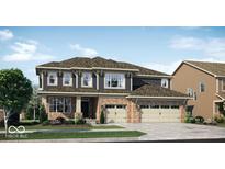 Charming two-story home boasts brick accents, a three-car garage, and a welcoming front yard at 11612 Aubrey Ln, Fishers, IN 46040