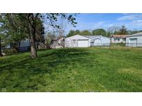 Spacious backyard featuring lush green grass and an oversized detached two-car garage at 1254 S Leland Ave, Indianapolis, IN 46203