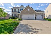 Charming two-story brick home featuring a three car garage, landscaped yard, and welcoming curb appeal at 1662 Cascade Dr, Greenwood, IN 46143