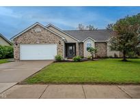 Charming single-story home with well-maintained lawn, brick accents, and attached two-car garage at 2557 Cedarcrest Dr, Columbus, IN 47203
