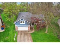 Aerial view of a beautiful blue house with a well-maintained lawn and mature trees at 524 Deerberry Dr, Noblesville, IN 46062