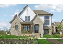 Charming two-story home featuring light brick, white siding, and a professionally landscaped yard at 579 Exmoor Dr, Carmel, IN 46032