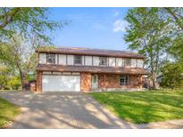 Charming two-story brick home with attached garage and well-maintained lawn in a tranquil neighborhood at 601 Ridgeview Ln, Columbus, IN 47201