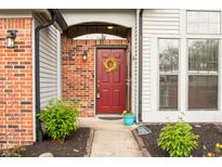 Charming red front door with decorative wreath and brick accents at 6140 King Lear Ln, Indianapolis, IN 46254