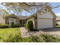 Charming single-story home featuring a 2-car garage, manicured lawn, and decorative brick accents at 6195 Woodmill Dr, Fishers, IN 46038