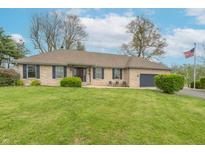 Charming brick ranch-style home with blue shutters, attached garage, and lush green lawn at 6212 Rocklane Rd, Greenwood, IN 46143