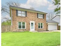 Charming two-story brick home with a well-maintained lawn and attached two-car garage at 6352 Watercrest Way, Indianapolis, IN 46278