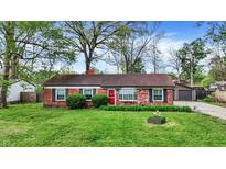 Charming brick home features a well-maintained lawn, red door, and neat landscaping at 6837 Doris Dr, Indianapolis, IN 46214