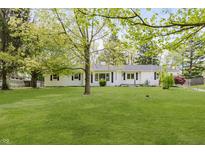 Charming, bright white home with well-maintained lawn, beautiful landscaping, and mature trees at 7950 Westfield Blvd, Indianapolis, IN 46240