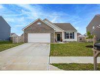 Charming home features a two-car garage, well-manicured lawn, and tasteful landscaping at 932 Sagittarius Ave, Franklin, IN 46131