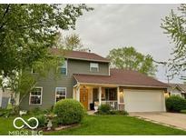 Charming two-story home with green siding, a well-manicured lawn, and an attached two-car garage at 1018 Redwood Dr, Lebanon, IN 46052