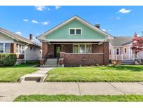 Charming brick home with a front porch and well-maintained lawn on a sunny day at 1029 E Yoke St, Indianapolis, IN 46203