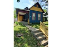 Charming blue home featuring a covered porch with detailed trim and a well-maintained front yard at 1050 Jefferson Ave, Indianapolis, IN 46201