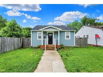 Charming light blue house with a black door, inviting front porch, and a well-maintained lawn at 1641 Iowa St, Indianapolis, IN 46203